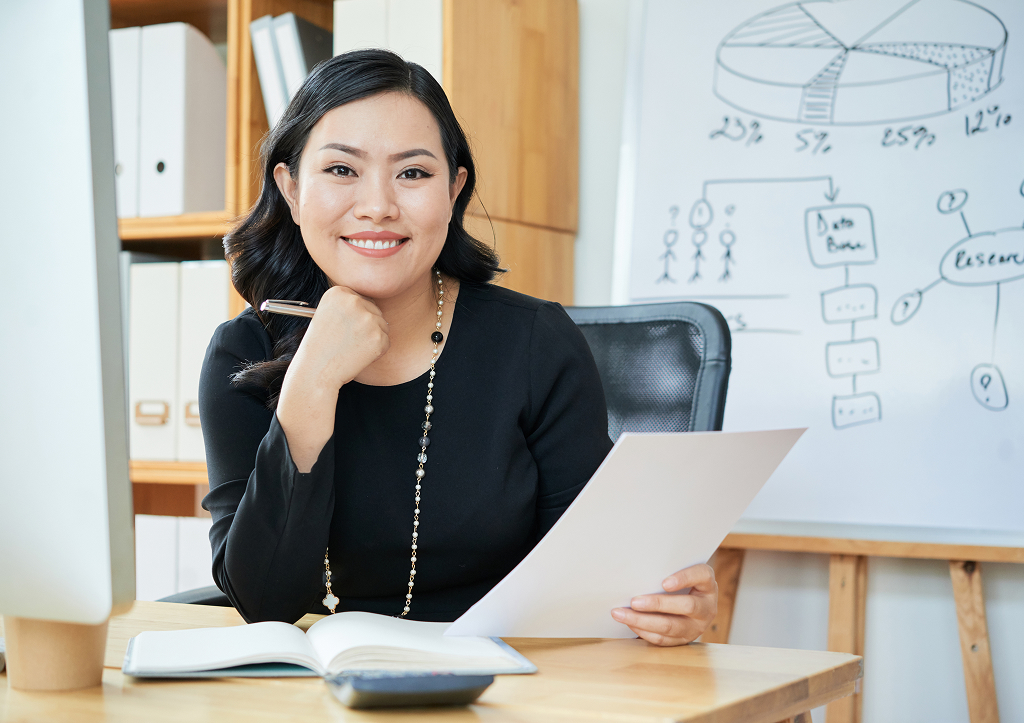 Smiling businesswoman working confidently at her office desk